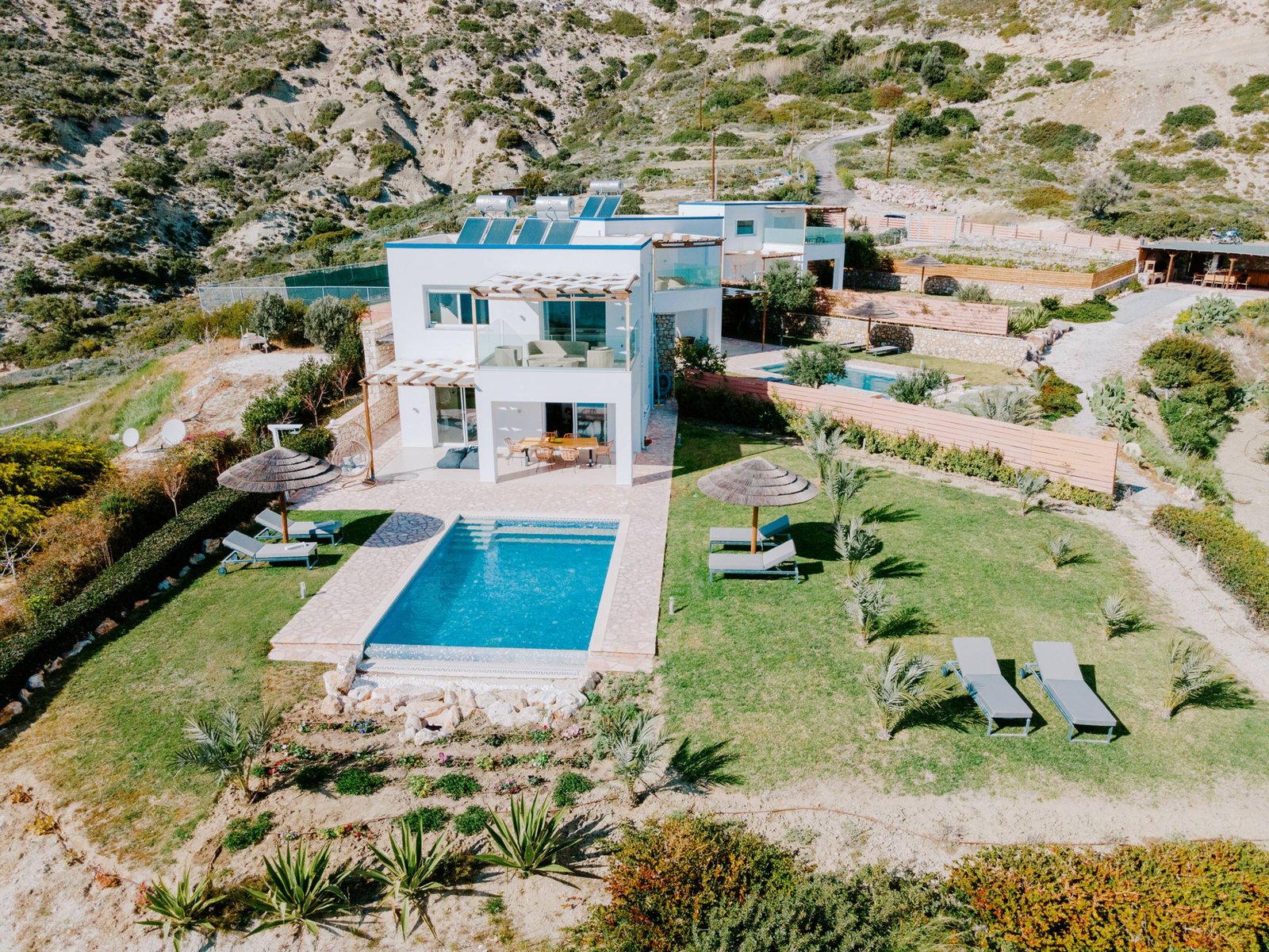 Villa front with pool, sun loungers and garden seen from above