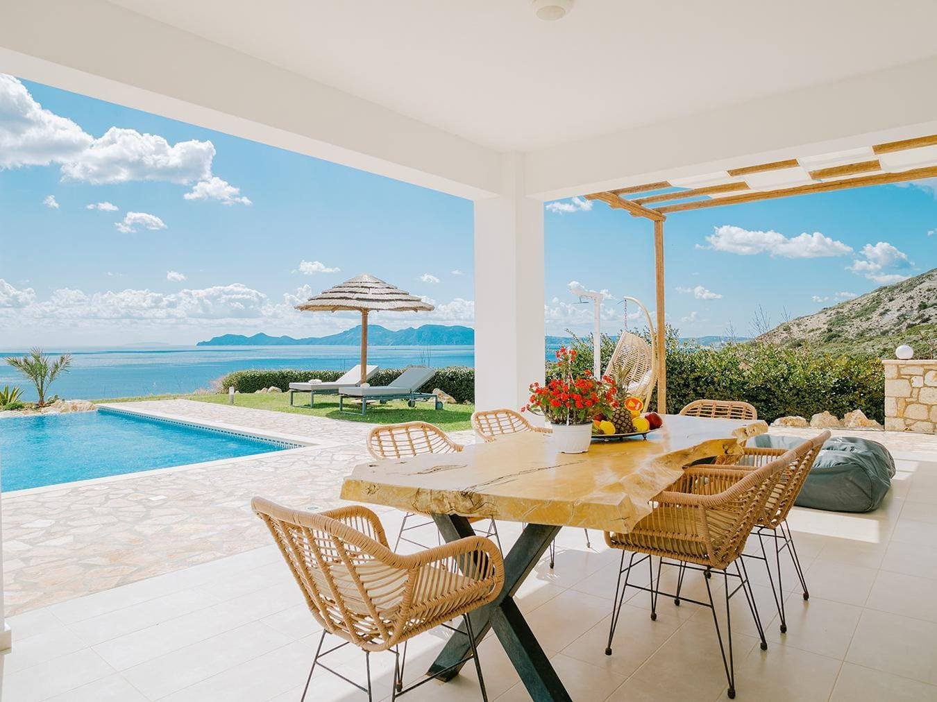 Villa Afrodite covered terrace dining table facing the pool and sea