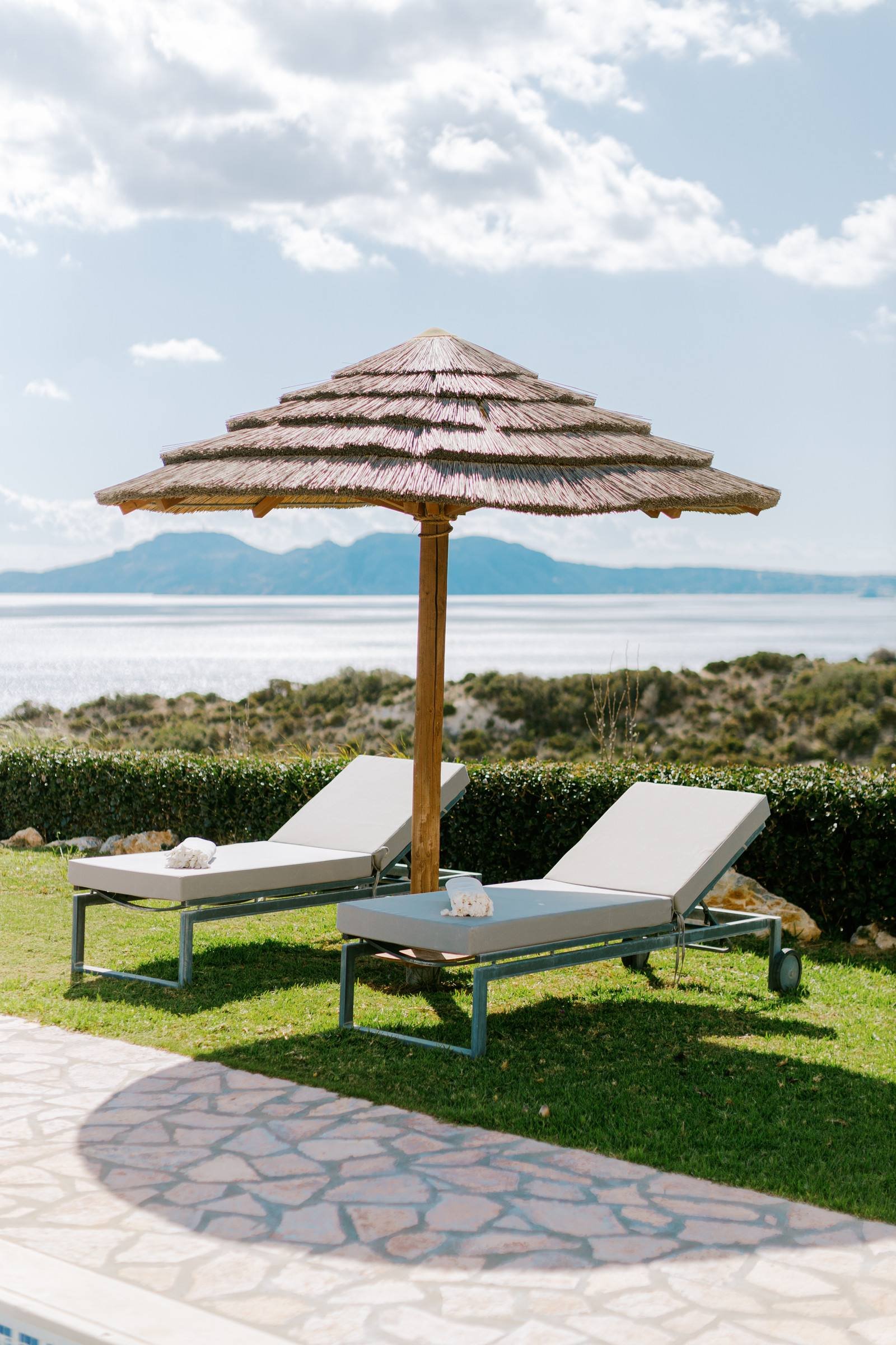 Thatched umbrella and loungers with sea view