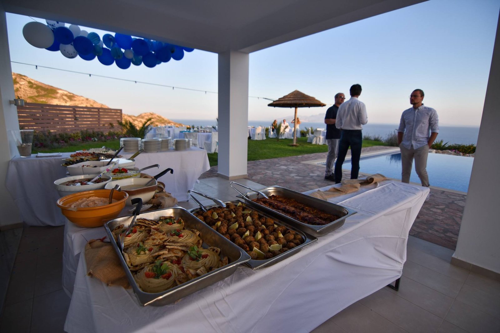 Buffet on the covered terrace with guests and sea view