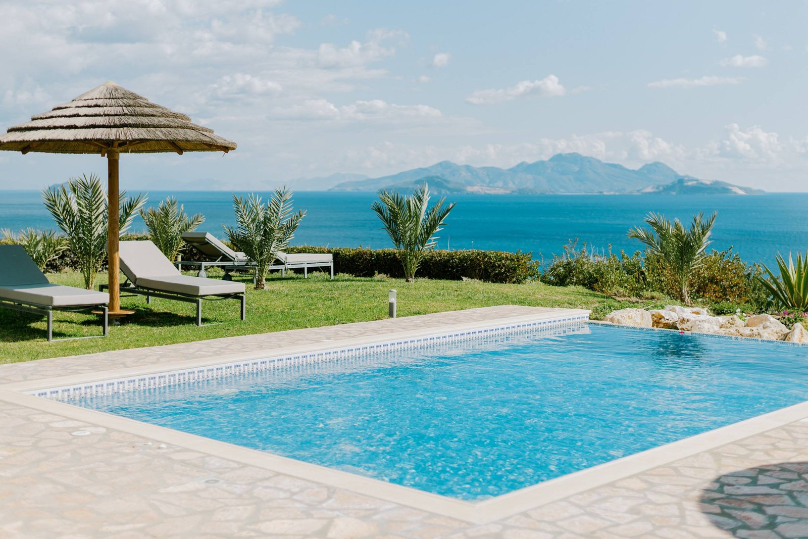 Pool and sun loungers looking out to the Aegean islands
