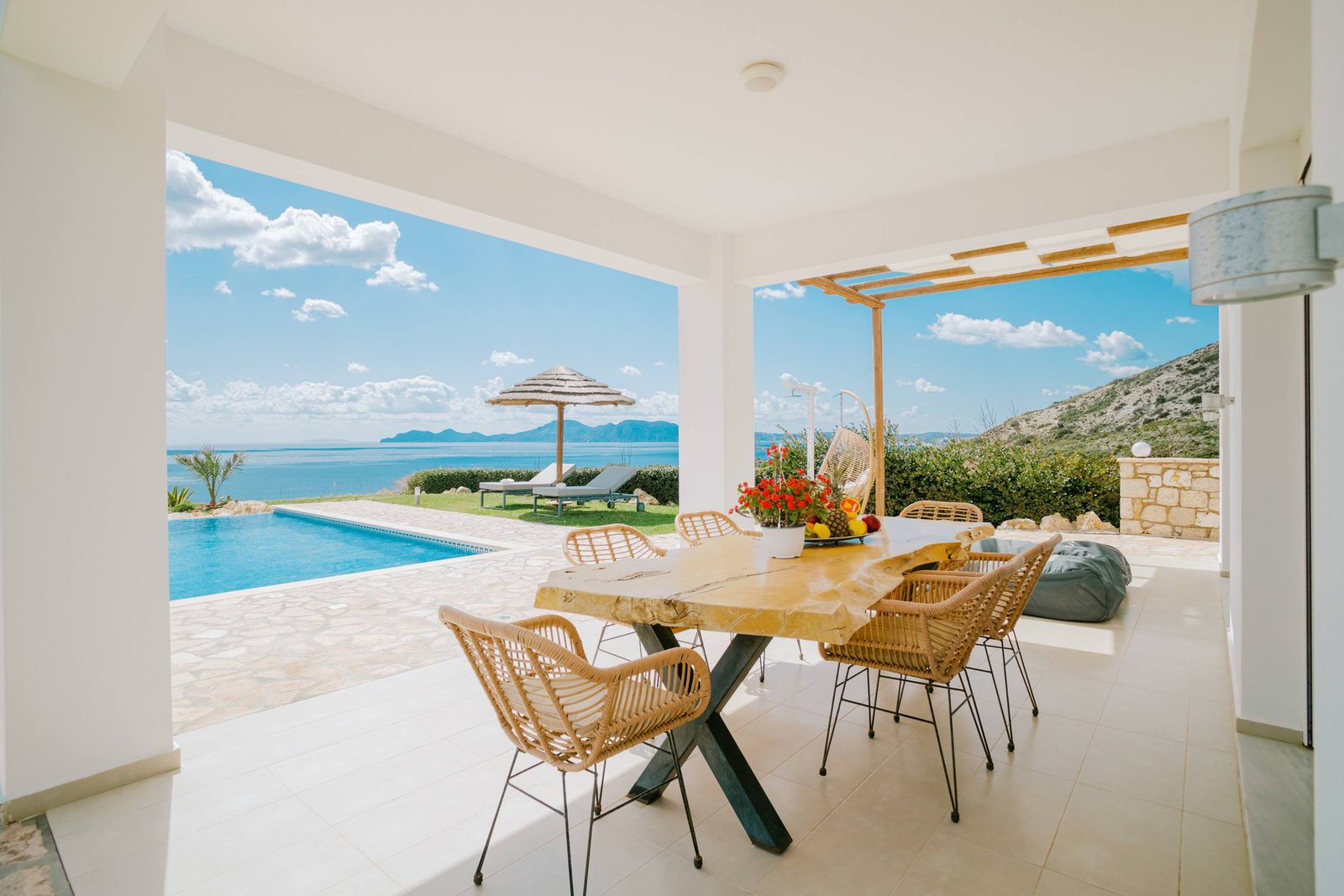 Outdoor dining table on the covered terrace facing the pool